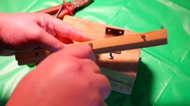 Tornavidayla çevirme. Ekip şoförü ve vidaları çalışıyor. Atölyede çalışıyorum. Tornavida metal çelik cıvatayı vidaladı. Anahtar, cıvata, vida ve fındık. Marangozluk atölyesinde ahşapla çalışmak..