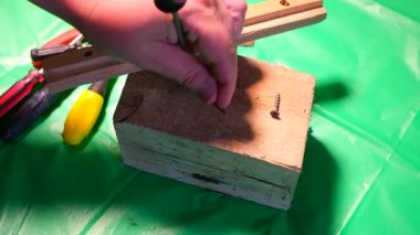 Tornavidayla çevirme. Ekip şoförü ve vidaları çalışıyor. Atölyede çalışıyorum. Tornavida metal çelik cıvatayı vidaladı. Anahtar, cıvata, vida ve fındık. Marangozluk atölyesinde ahşapla çalışmak..