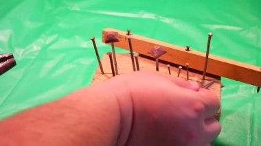 Penseyle çivi söküyorum. Marangoz kerpeteni kurtarma, yardım konsepti teması. İşçi, eğri çiviyi penseyle söküyor. Ahşap işçilerinin elleri kapalı..