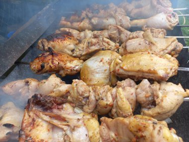 Tavuk ızgarada. Kızarmış tavuk yanıyor. Şiş üstünde et. Tavuk kebabı. ateşte et pişirmek. Ev mangalı. Izgara yemek..