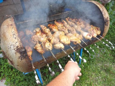 Tavuk ızgarada. Kızarmış tavuk yanıyor. Şiş üstünde et. Tavuk kebabı. ateşte et pişirmek. Ev mangalı. Izgara yemek..