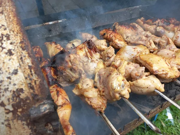Tavuk ızgarada. Kızarmış tavuk yanıyor. Şiş üstünde et. Tavuk kebabı. ateşte et pişirmek. Ev mangalı. Izgara yemek..
