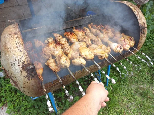 Tavuk ızgarada. Kızarmış tavuk yanıyor. Şiş üstünde et. Tavuk kebabı. ateşte et pişirmek. Ev mangalı. Izgara yemek..