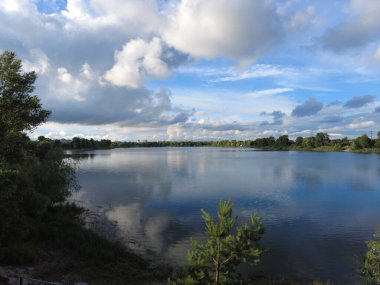 Su ve bulutlarla dolu güzel bir manzara. Ukrayna. Ukrayna manzarası. Güzel bir akşam manzarası. Doğal duvar kağıdı. Geniş nehir. Nehirde bir yaz akşamı.