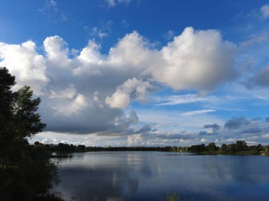 Su ve bulutlarla dolu güzel bir manzara. Ukrayna. Ukrayna manzarası. Güzel bir akşam manzarası. Doğal duvar kağıdı. Geniş nehir. Nehirde bir yaz akşamı.