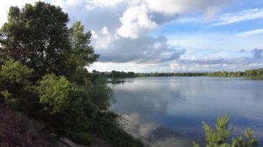 Su ve bulutlarla dolu güzel bir manzara. Ukrayna. Ukrayna manzarası. Güzel bir akşam manzarası. Doğal duvar kağıdı. Geniş nehir. Nehirde bir yaz akşamı.