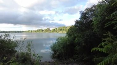 Su ve bulutlarla dolu güzel bir manzara. Ukrayna. Ukrayna manzarası. Güzel bir akşam manzarası. Doğal duvar kağıdı. Geniş nehir. Nehirde bir yaz akşamı.