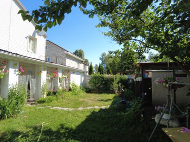 Avlu. Köy evi. Ev bahçesi. Çimler ve çiçekler. Rahatlamak için avlu. Yaz bahçesi.