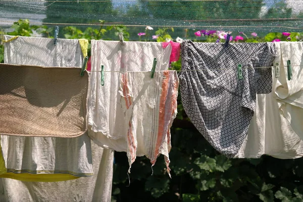 clothes on a rope. Wash clothes on a rope with clothespins on background. Rope with clean clothes outdoors on laundry day