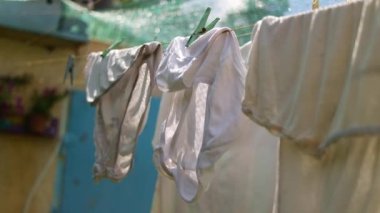 clothes on a rope. Wash clothes on a rope with clothespins on background. Rope with clean clothes outdoors on laundry day