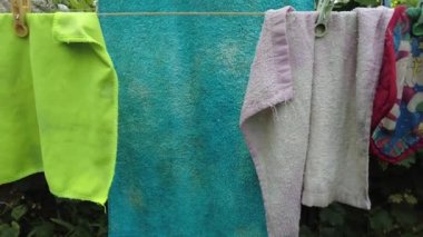 Giysiler ipte. İpe asılmış külot. Kırmızı şort. Kıyafetler dışarıda kurumuş. Yıkandıktan sonra. Temiz çarşaf. eski keten.