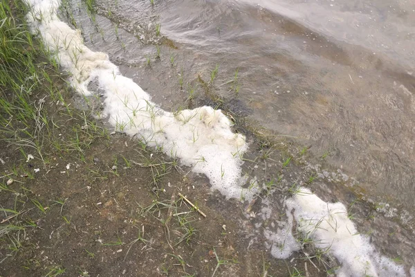 sea foam. foam on the shore. river water with foam. white foam on the sand. b