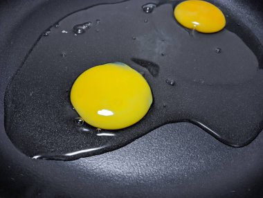 scrambled eggs in a pan. broken chicken eggs. Broken raw chicken egg in a frying pan. Cooking scrambled eggs. Cooking scrambled fried eggs, the egg broke together with the shell. Rush. Trouble happens.