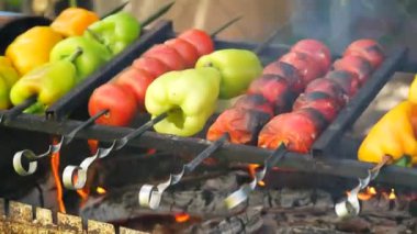 fried vegetables on fire. tomatoes and sweet peppers on fire. vegan menu. vegetables and barbecue. Vegetable barbecue on skewers frying on a grill brazier. close up