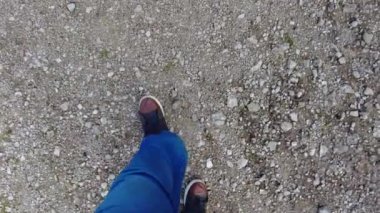 Gri yol. Cinder Yolu. video 4k. Koyu gri kül taşları toprak bir yolda uzanır. Gün ortası güneşinin en üst manzarası. Yoldaki tekdüzelikler. Yoldaki trafik.