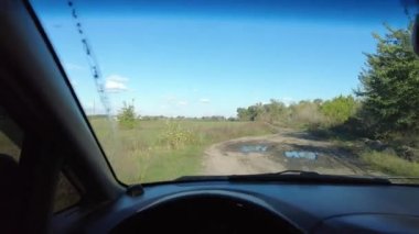 Arabanın içinde. Şoför kullanıyor. Kötü bir yolda araba kullanmak. Arabayla yolculuk. Yoldaki delikler. video 4k. yüksek çözünürlüklü