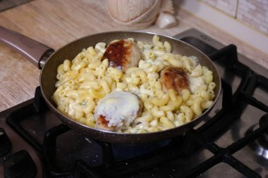 tavada makarna. Fusilli makarna tavada kaynar suda kaynatılır. Yavaş rotasyon. Soslu makarna kızartma paneline kremayla doldurulur. Peynir ve makarna. Köfte ve makarna.