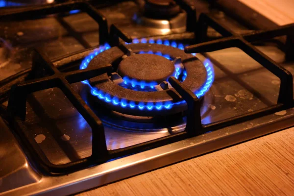 gas burns. gas hob. The gas turns on, a blue flame appears. Gas stove on a black background. The kitchen burner turns on. The top burner is ignited in a blue flame for cooking.