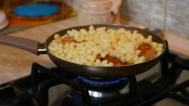 tavada makarna. Fusilli makarna tavada kaynar suda kaynatılır. Yavaş rotasyon. Soslu makarna kızartma paneline kremayla doldurulur. Peynir ve makarna. Köfte ve makarna.