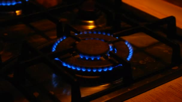 气体燃烧 煤气灶 气体打开 蓝色的火焰出现了 黑色背景上的煤气炉 厨房的燃烧器打开了 顶部的燃烧器在蓝色的火焰中点火做饭 — 图库视频影像