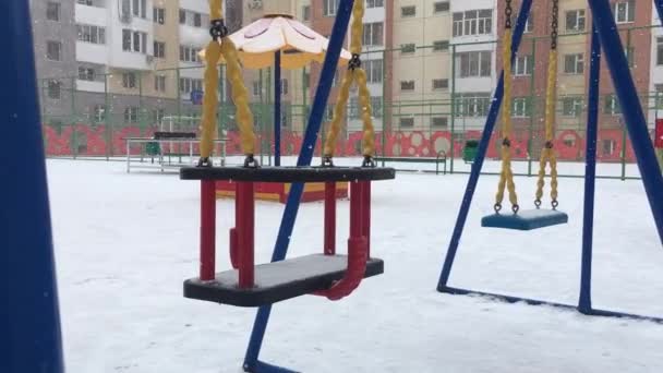 Empty swing. coronavirus quarantine.playground winter snowfall — Stock Video