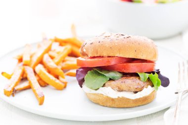 Kızarmış portobello mantarlı burger, kepekli çörek ve patates kızartması..