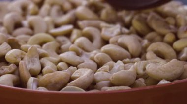 Odunların üzerine kamera doldur, kaşıkla kaselerden çiğ kaju kepçesi getir..