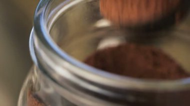 Kavanozdan taze kahve telvesi alınıyor..