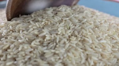Kahverengi pirinç kasede kepçelenip tahta kaşığa konuyor.