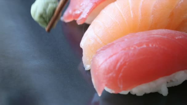 用金枪鱼和鲑鱼寿司卷把芥末球放在盘子里 — 图库视频影像