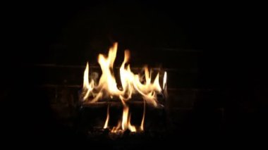 Firelog burning in hearth surrounded by black