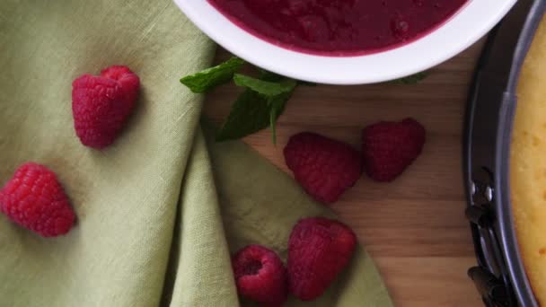 Flat Lay Tracking Shot Table Rasberries Raspberry Sauce Whole Cheesecake — Stockvideo