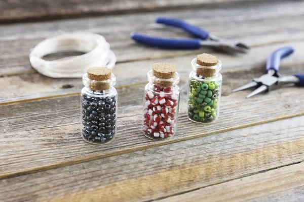 Red Green Black Seed Beads Small Jars Wooden Surface Wire — 图库照片