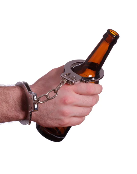 Алкоголизм с наручниками и бутылками — стоковое фото