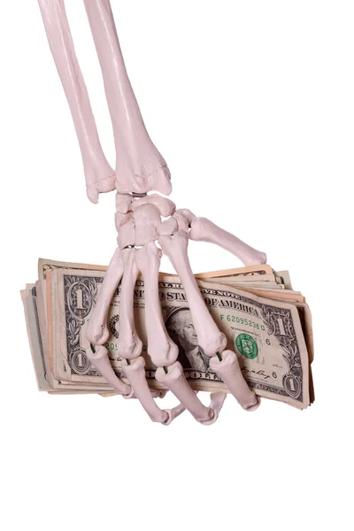 Скелетные пальцы держат доллары — стоковое фото