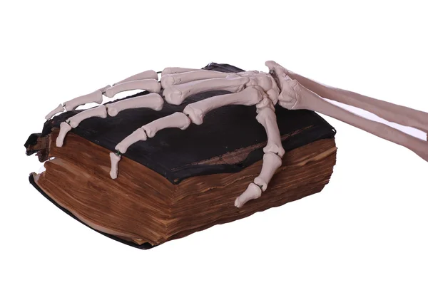 Vieux livre avec la main squelette — Photo