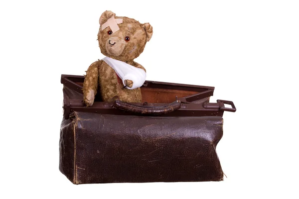 Старий хворий плюшевий ведмідь на валізі — стокове фото
