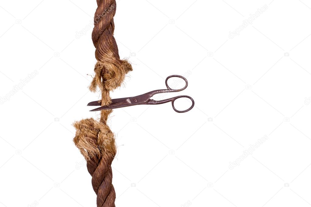 Cutting A Rope With Scissors Against White Background Stock Photo