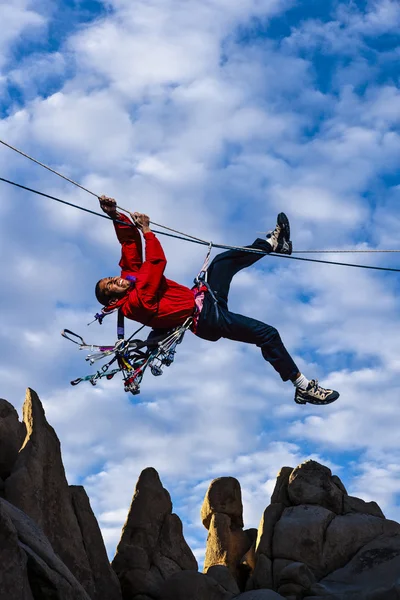 Climber pulls across a tyrollean traverse. — Stock Photo, Image