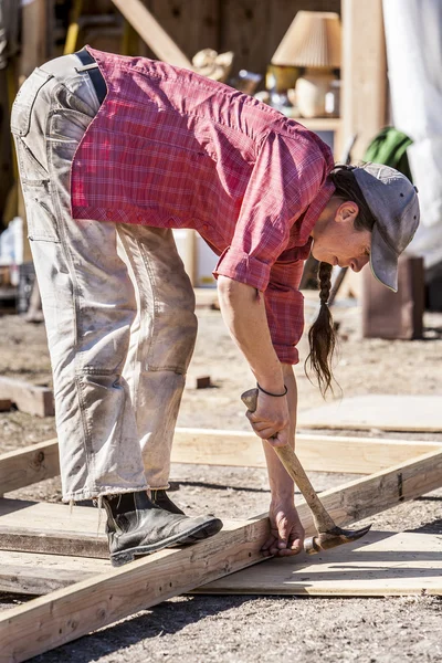 Feminino carpinteiro martelos um prego . — Fotografia de Stock