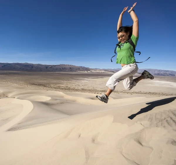 Female hiker climbing sand dunes. — Stock Photo, Image