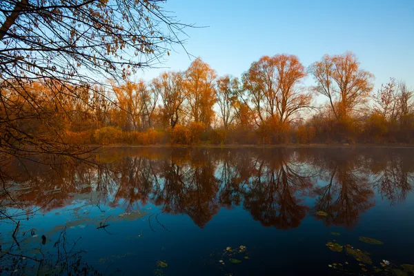 Uitzicht op het herfstlandschap van rivier en bomen op zonnige dag — Stockfoto