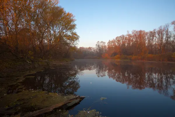 Güneşli bir günde nehir ve ağaçların sonbahar manzarasını izle — Stok fotoğraf