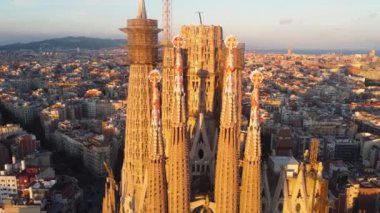Barcelona, Katalonya, İspanya 'daki Sagrada Familia Tapınağı. Gün doğumunda Gaudi 'nin mimari başyapıtının etrafında uçan UHD, 4K