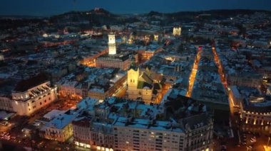 Antik şehrin panoraması. Belediye meclisi, belediye binası, eski kilise Lviv Latin Katedrali. Eski binaların çatıları. Hava, insansız hava aracı görüntüsü. Kış gecesi. lviv, Ukrayna
