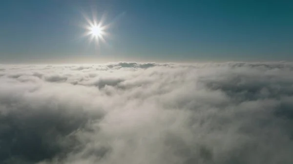 Sonnenlichte Kumuluswolken unter dem Horizont. über den Kumuluswolken am Morgen. — Stockfoto