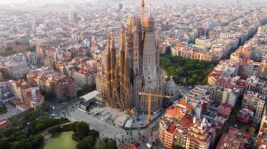 Barcelona, Katalonya, İspanya 'daki Sagrada Familia Tapınağı. Gün doğumunda Gaudi 'nin mimari başyapıtının etrafında uçan UHD, 4K