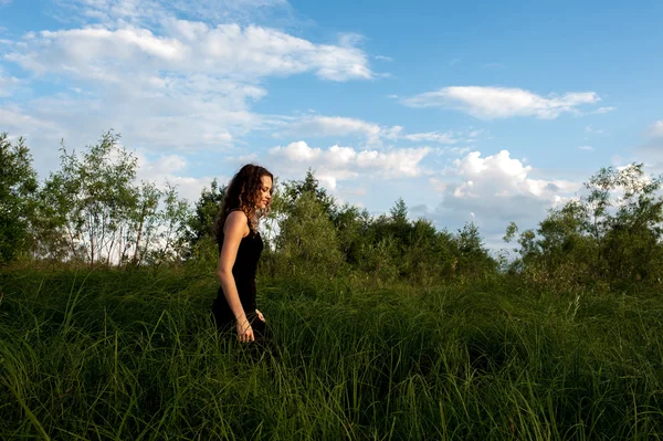 美丽的女孩走在高草 — 图库照片