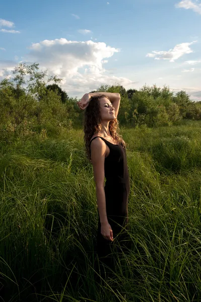 Mooi meisje wandelingen in hoog gras — Stockfoto