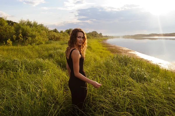 Beautiful girl walks in high grass — Stock Photo, Image